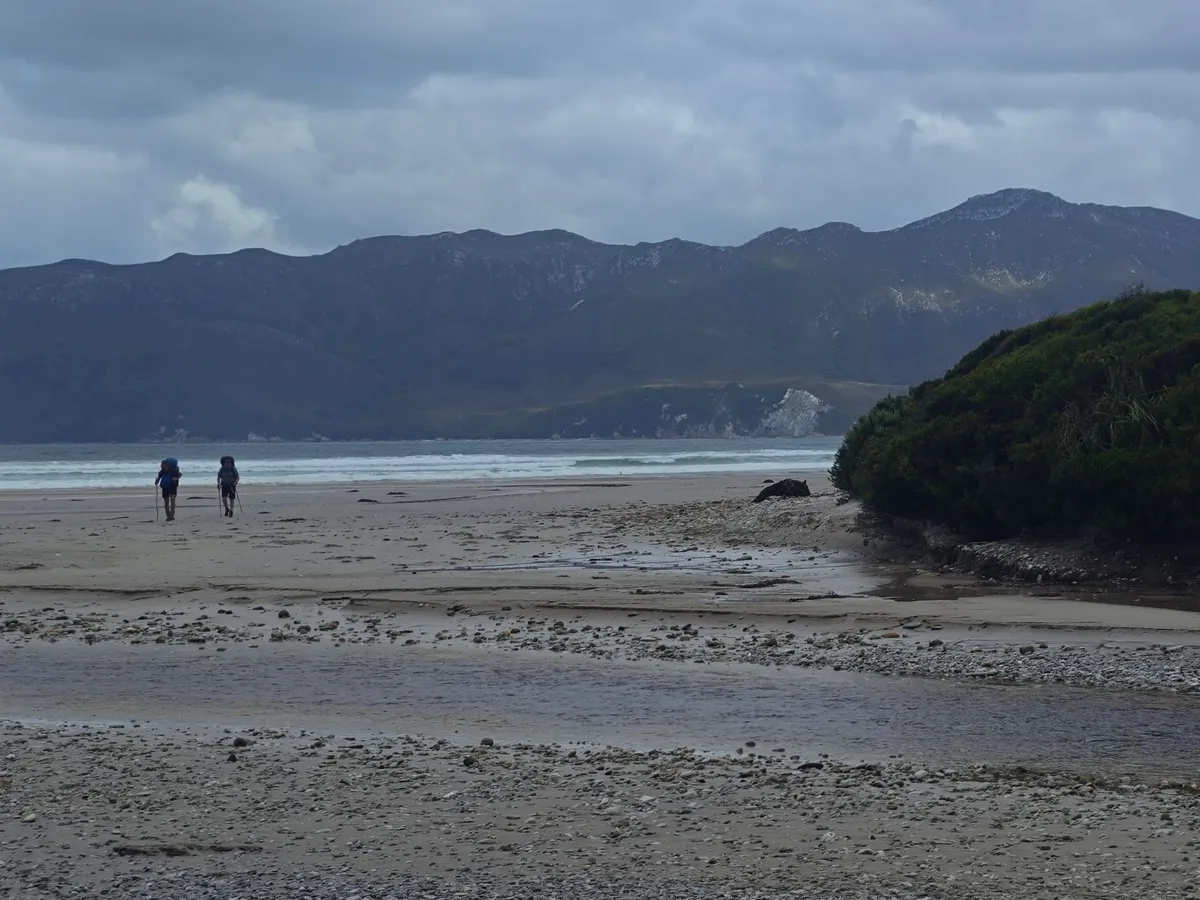 Randonneurs remontant la plage de Cox Bight