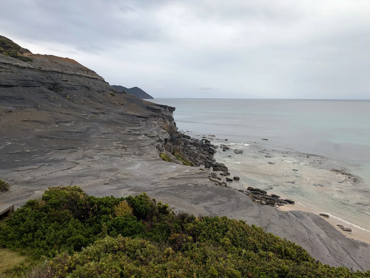 Falaise de roches sombres au dessus de l'océan