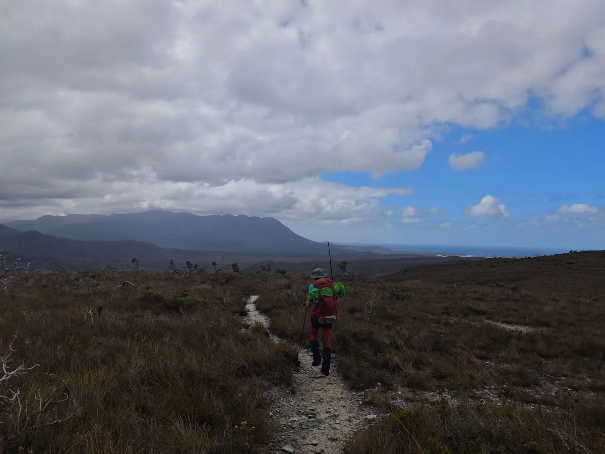 Randonneur marchant vers une montagne couverte